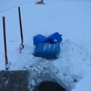 First, hack a hole into the river ice with a pickax. Then cover it with plywood so it won't freeze over again.