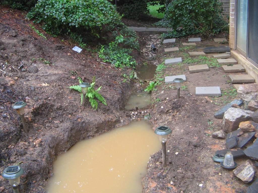 during heavy run there is a shocking amount of water flowing through here. I want it to run over the gravel then through some plants in the trench and