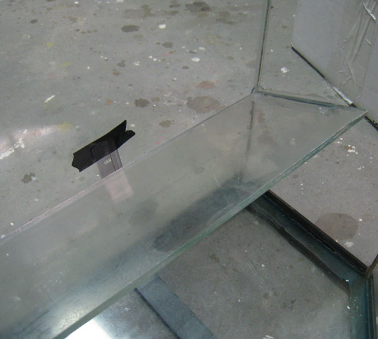 I put a thin object (razor blade) behind the the glass plate to leave a thin space. I did not want the glass plate flush against the back of the tank.